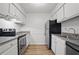 Galley kitchen featuring white cabinetry, stainless steel appliances, and hardwood floors at 5157 Roswell Rd # 1, Atlanta, GA 30342