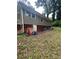 Exterior of a home with a white door leading to a basement and a small yard with some debris at 2708 Beacon Dr, Atlanta, GA 30360