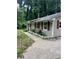 Close up of the right side of a home with neutral siding, burgundy shutters, and concrete walkway at 2708 Beacon Dr, Atlanta, GA 30360