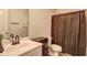 Well-lit bathroom featuring a single sink vanity, toilet and shower with curtain at 336 Freeman Cir, Villa Rica, GA 30180