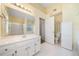 Bright bathroom features white tile floors, large mirror, and storage at 467 Ravinia Way, Lawrenceville, GA 30044