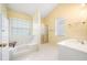 Sunlit bathroom boasts a tub, shower, and a single sink vanity at 467 Ravinia Way, Lawrenceville, GA 30044