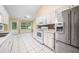 Well-lit kitchen with stainless steel refrigerator, range, ample white cabinets, and backyard view at 467 Ravinia Way, Lawrenceville, GA 30044