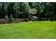 A backyard with lush lawn, wooden fence, storage shed, and trees create a private setting at 5778 Little Oak Trl, Stone Mountain, GA 30087