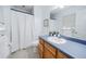Well-lit bathroom featuring a combination shower-tub with a toilet, a single sink, and a large mirror at 5778 Little Oak Trl, Stone Mountain, GA 30087