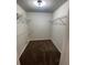 Walk-in closet with metal shelving and dark wood floors at 2166 Lake Ridge Ter, Lawrenceville, GA 30043