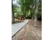 Brick home exterior featuring a new driveway and lush, mature trees at 2166 Lake Ridge Ter, Lawrenceville, GA 30043