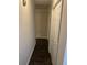 Hallway with dark hardwood floors and neutral paint leading to bedrooms with ample closet space at 2166 Lake Ridge Ter, Lawrenceville, GA 30043