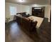 Cozy living room featuring a plush leather sofa, a large tv and entertainment center, and wood flooring at 2166 Lake Ridge Ter, Lawrenceville, GA 30043
