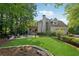 Beautiful backyard featuring a manicured lawn, fire pit, and stone patio with lush landscaping at 4750 Freeport Bay Ne, Roswell, GA 30075