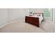 Bedroom with a dark wood bed frame, plush carpet, and bright windows at 4750 Freeport Bay Ne, Roswell, GA 30075