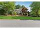 Suburban home with a manicured lawn, mature trees, and a stone-and-siding facade at 4750 Freeport Bay Ne, Roswell, GA 30075