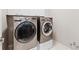 Modern laundry room features a side-by-side washer and dryer and storage cabinets at 4750 Freeport Bay Ne, Roswell, GA 30075