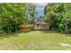 A backyard with grass that leads to a utility shed and wooden privacy fence at 61 Springside Se Dr, Atlanta, GA 30354