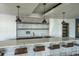 Modern kitchen bar area with a stone backsplash, quartz countertop, floating shelves, and pendant lighting at 943 Peachtree Ne St # 1518, Atlanta, GA 30309