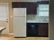 Functional kitchen with white refrigerator, dark cabinets, and a stainless steel sink at 186 Grapevine Dr, Douglasville, GA 30134