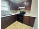 Well-equipped kitchen with dark wood cabinets and modern black appliances at 186 Grapevine Dr, Douglasville, GA 30134