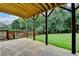 Backyard patio with wood pillars, with a lush, green lawn perfect for outdoor entertaining at 3760 Ansley Park Dr, Suwanee, GA 30024