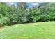 Large grassy backyard surrounded by a variety of trees and lush vegetation at 3760 Ansley Park Dr, Suwanee, GA 30024