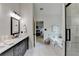 Well-lit bathroom with marble floors, walk-in shower, and soaking tub at 3760 Ansley Park Dr, Suwanee, GA 30024