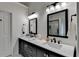 Bathroom featuring dual sinks, quartz countertops, and modern fixtures with vanity lighting at 3760 Ansley Park Dr, Suwanee, GA 30024