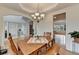 Bright dining room with hardwood floors and classic chandelier opens to foyer and living room at 3760 Ansley Park Dr, Suwanee, GA 30024