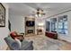 Comfortable living room featuring a stone fireplace, ceiling fan, and large windows at 3760 Ansley Park Dr, Suwanee, GA 30024