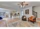 Open-concept living room featuring hardwood floors, a ceiling fan, and elegant decor near an eat-in kitchen at 3760 Ansley Park Dr, Suwanee, GA 30024