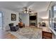 Relaxing living room with fireplace, ceiling fan, hardwood floors, and natural light at 3760 Ansley Park Dr, Suwanee, GA 30024