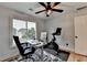Home office featuring large window, modern desk, ceiling fan, and exercise equipment at 3760 Ansley Park Dr, Suwanee, GA 30024