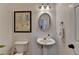 Cozy powder room with pedestal sink, decorative mirror, and classic fixtures near the main entrance at 3760 Ansley Park Dr, Suwanee, GA 30024