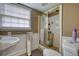 Bathroom with shower stall with glass doors, sink, toilet and window with blinds at 493 James Street Sw, Lilburn, GA 30047