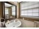 Bathroom features sink, mirror and shower with white and brown accents at 493 James Street Sw, Lilburn, GA 30047