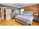 Bedroom with wood floors, a modern wood accent wall and multiple windows at 493 James Street Sw, Lilburn, GA 30047