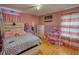 Bright bedroom with pink and purple walls, hardwood flooring, and stylish furniture at 493 James Street Sw, Lilburn, GA 30047