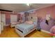 Large bedroom featuring pink and purple walls, hardwood flooring, and two beds at 493 James Street Sw, Lilburn, GA 30047