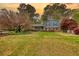 Charming two-story home with a manicured lawn and mature trees, showcasing curb appeal at 493 James Street Sw, Lilburn, GA 30047