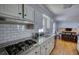 Modern kitchen showcases stainless steel appliances, granite countertops, and white subway tile backsplash at 493 James Street Sw, Lilburn, GA 30047