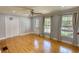 Bright living room boasts hardwood floors, ceiling fan, and sunlit windows with stylish curtains at 493 James Street Sw, Lilburn, GA 30047