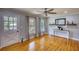 Cozy living room featuring beautiful hardwood floors, a ceiling fan, and natural light from large windows at 493 James Street Sw, Lilburn, GA 30047