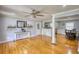 Open-concept living space with hardwood floors, stylish console table, and seamless flow to dining area at 493 James Street Sw, Lilburn, GA 30047