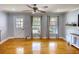 Bright living room features hardwood floors, a ceiling fan, and sunlit windows creating a cozy space at 493 James Street Sw, Lilburn, GA 30047