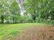Large backyard view featuring mature trees surrounding the home's property at 6616 King George Way, Morrow, GA 30260