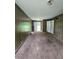View of living room with carpet, wood paneled walls and an open doorway at 6616 King George Way, Morrow, GA 30260