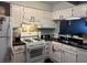 Traditional kitchen featuring white cabinets, black countertops, and a gas range at 6620 Wellington Sq, Norcross, GA 30093