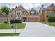 Inviting two-story home featuring a stone accents, a two-car garage, and a well-manicured front lawn at 1267 Castleberry Dr, Buford, GA 30518