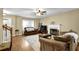 Inviting living room with fireplace, ceiling fan, hardwood floors, and large windows for natural light at 1267 Castleberry Dr, Buford, GA 30518