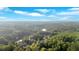 Aerial view showcasing a neighborhood surrounded by lush greenery and tranquil lake at 1220 Waterfall Nw Ln, Acworth, GA 30101