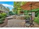 A backyard pool area with an umbrella, a poolside seating area, and lush greenery around the stone-lined pool at 1220 Waterfall Nw Ln, Acworth, GA 30101