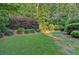 Expansive backyard with lush greenery, mature trees, and a custom putting green at 1220 Waterfall Nw Ln, Acworth, GA 30101